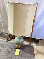 Full view of lamp showing blue ceramic body, brass base, and shade