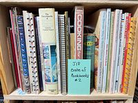 Front view of shelf showing entire group of cookbooks and sticky note