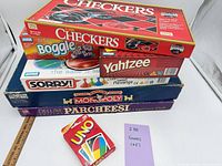 Stacked view of all seven game boxes and Uno deck