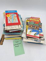 Two stacks of assorted folded maps with Baedeker London and Australia maps visible, ruler for scale