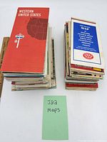 Two stacks of folded maps with ruler for scale