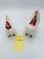 Front view of both ceramic rooster figurines
