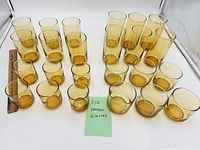 24 amber glass tumblers in four rows by size