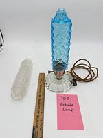 Full view of blue glass bedside lamp, spare clear shade and ruler for scale