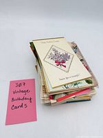Stack of vintage birthday cards showing floral cover on top