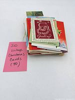 Stack of vintage Christmas cards with pink tag noting quantity