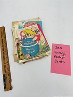 Stack of vintage Easter cards beside ruler