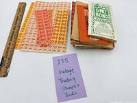 Overview of stamp saver books stack and assorted stamp sheets with ruler for scale