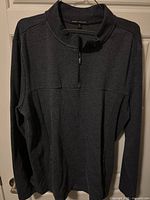 Front view of charcoal grey quarter-zip pullover on hanger
