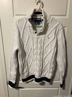 Front view of white cable knit quarter-zip sweater