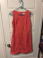 Full view of pink sleeveless dress hanging