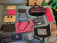 Overall view of fifteen wallets and bags laid out on sofa