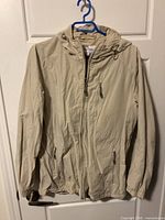 Front view of beige Calvin Klein windbreaker jacket on hanger