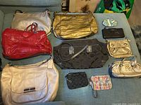 Overview of all Coach handbags and wallets laid out on sofa
