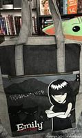 Front view showing Emily graphic, zip pocket and handles
