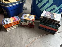 Three stacks of assorted fantasy and sci-fi paperbacks on floor