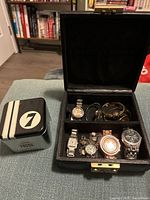 Closed Fossil tin, open leather watch case showing all contents