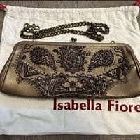 Front of bronze beaded clutch on dust bag showing beadwork and chain strap