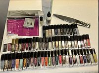 Overview of entire lot showing rows of nail polishes, Plie Wand set, nail care items, and metal file