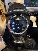 Front view of Lavazza capsule machine showing overall form and water tank