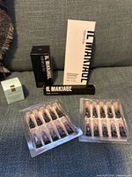 Group shot of all boxed Il Makiage items, Avon sample packs, and Estée Lauder crème