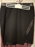 Front view of black skirt showing faux-leather trim