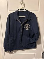 Front view of navy jacket on hanger showing overall design