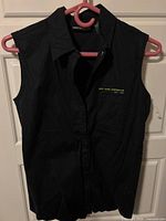 Front view of black DKNY sleeveless shirt on hanger