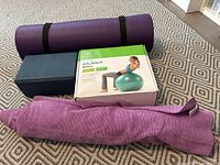 All four items together: yoga mat, balance ball box, yoga block, blanket-towel