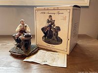 Figurine, certificate and box displayed together