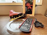 Lot overview showing red skate, pressed-glass plate, sled sign, gingerbread pan, boxed arrangement rear