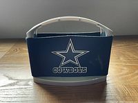 Front view of blue neoprene sleeve on plastic carrier showing Dallas Cowboys star logo