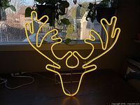 LED neon reindeer sign illuminated showing yellow glow
