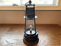 Front view of black metal lantern on wood surface