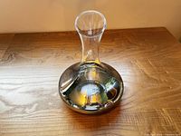 Full view of glass decanter showing flared neck and mirrored lower section