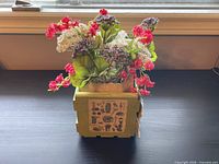 Front view of green wooden crate with faux flower arrangement and decoupage panel
