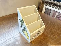 Left-front perspective showing lemon artwork and three compartments