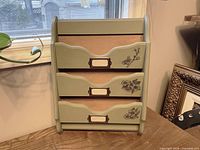 Front view of green three-tier mail sorter standing upright