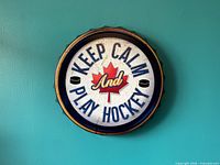 front view of round metal bottle cap sign showing text and graphics