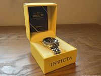 Watch in open yellow Invicta box with booklet