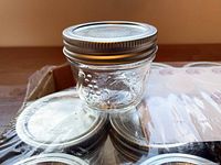 Close-up of a single jar and lid on top of the sealed pack