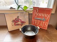 Overall lot showing sign, framed map art, and metal pail