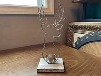 Front view of silver plated reindeer tealight holder on wooden base