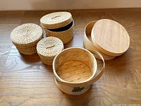 All baskets grouped: three wicker nesting baskets, bamboo handled basket, wooden oval box