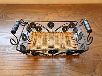 Angled view of rectangular wire tray showing wicker base and wooden handles