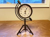 Front view of William Sutton table clock on tripod stand