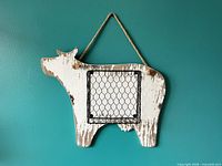 Front view of wood cow silhouette with chicken-wire basket and rope hanger