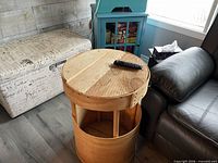 Table beside couch showing cylindrical base and plank top