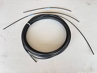 coil with three short cut lengths of black nylon-coated wire rope
