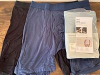 Two boxer briefs laid out, black and slate blue-gray